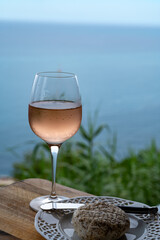 Summer time in Provence, glass of cold rose wine and goat cheese with blue sea view on background, French Riviera near Menton, south of France