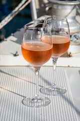 Party with rose wine on yacht boat anchored in port la Rague, Gulf of La Napoule, in Provence, two glasses of cold rose wine, French Riviera near Cannes, south of France