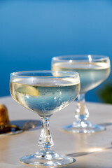 Cold sparkling wine, cava or champagne in two coupe glasses on table with blue sea water view, French Riviera is summer, France