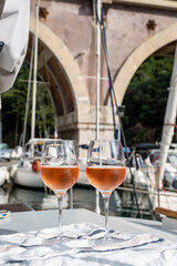 Party with rose wine on yacht boat anchored in port la Rague, Gulf of La Napoule, in Provence, two glasses of cold rose wine, French Riviera near Cannes, south of France
