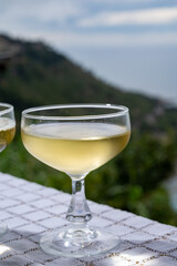 Cold sparkling wine, cava or champagne in two coupe glasses on table with sea water view