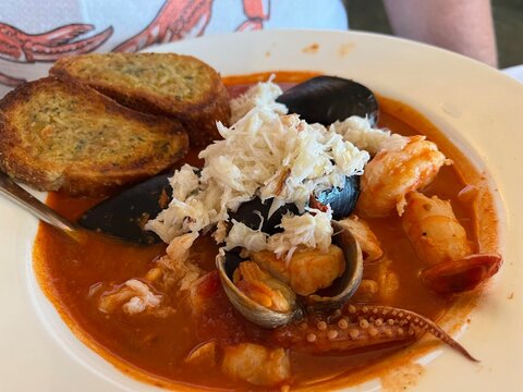 Seafood cioppino in a bowl with garlic bread