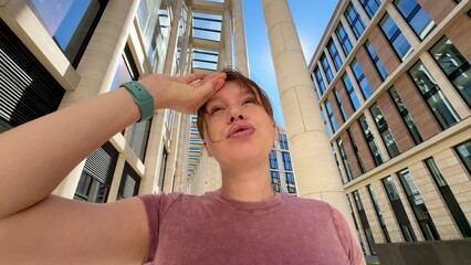 Fototapeta premium Young tired thirsty woman is suffering of heat at summer sunny day, having sunstroke outdoors