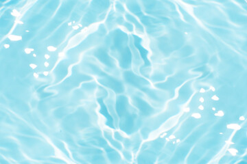 Blue water with ripples on the surface. Defocus blurred transparent blue colored clear calm water surface texture with splashes and bubbles. Water waves with shining pattern texture background.