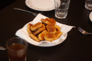dinner table with chicken nuggets, sausages, fries and salad.