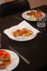 dinner table with chicken nuggets, sausages, fries and salad.