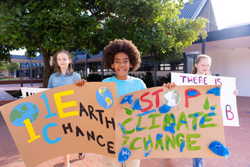 Happy diverse schoolchildren holding ecology posters made in art class outside school - Powered by Adobe