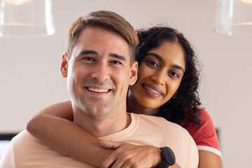 Embracing and smiling, young couple enjoying time together indoors