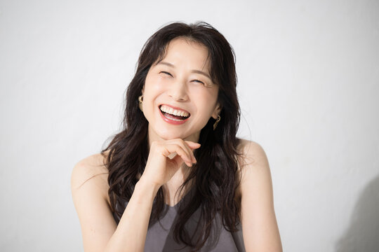 顎に手を当てる女性のカメラ目線　美容やビューティーなどに 40代や50代の美しいスキンケアなどの健康的なイメージに