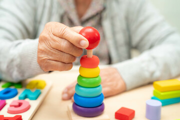 Alzheimer disease AD, Asian senior woman patient suffering from dementia learn practical motor...