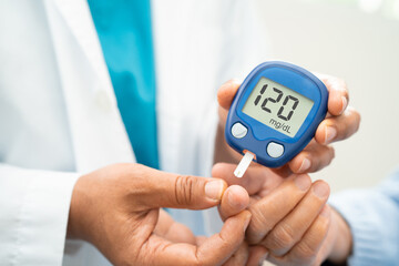 Doctor use digital glucose monitor measure and test stripe for check diabetes from finger blood sugar level.