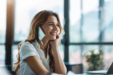 Obraz premium Happy businesswoman discussing a project on a phone call while working in her office