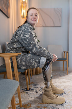 Wearing undefined uniform, woman with prosthetic leg sitting in waiting area