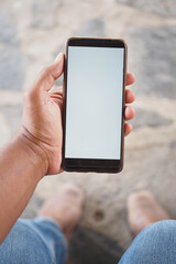 pov of young man hand using smart phone while siting outdoor 