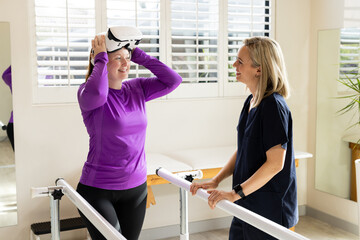 Woman in prosthetic leg adjusting VR headset with therapist in rehabilitation center