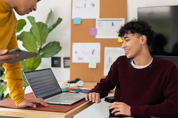 Working from home, smiling man using laptop and discussing with partner