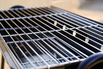 Close-up shot of stainless steel grill tray. Charcoal grill. Standing grill. Grill and barbeque. Outdoor party. Cooking tools. Kitchen set. Kitchen equipment photo concept