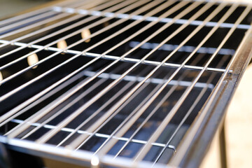 Close-up shot of stainless steel grill tray. Charcoal grill. Standing grill. Grill and barbeque. Outdoor party. Cooking tools. Kitchen set. Kitchen equipment photo concept