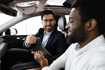 Interaction characterized by professionalism, trust, and satisfaction. Caucasian car dealer sits...
