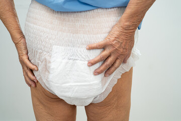 Asian elderly woman wearing diaper for loss of bladder urinary incontinence control.