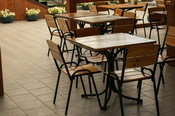 Outdoor Cafe Terrace with Empty Wooden Tables and Chairs on a Sunny Day
