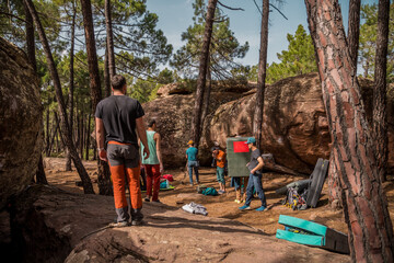 Group of climbers preparing to climb in a pine forest. © Alejandro Vicente