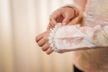 Woman adjusting beaded sleeve of traditional dress