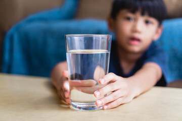 kid holding glass of water for dringking, healthy lifestyle concept