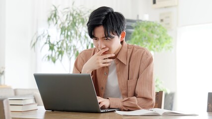 Fototapeta premium パソコンを見て考える男性