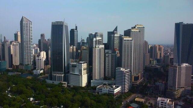 Drone approaching highrise in the sunlit Makati skyline, in Manila, Philippines