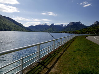 Isolated fishing rod in Annecy lake in Haute savoie, france with alpine mountains in spring