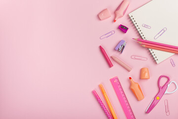 Back to school concept. pencils, sharpener, scissors, pens on pink background with copy space. Flat lay, top view.