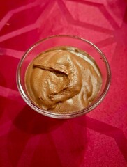 cup of chocolate mousse on top of a red tablecloth
