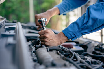 close up of view Hand Auto mechanic repairman using a socket wrench working engine repair in the garage, change spare part, check the mileage of the car, checking and maintenance service concept.