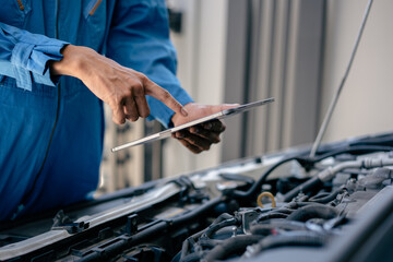 Automotive mechanic repairman using tablet to checking engine room, check the mileage of the car, oil change, car auto service, auto maintenance service concept.