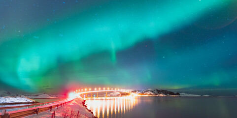 Sommaroy Bridge is a cantilever bridge connecting the islands of Kvaloya and Sommaroy with Aurora Borealis - Hillesoy Tromso Norway