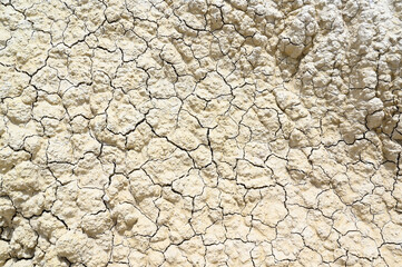 Dry cracks in desert Biosphere Reserve Bardenas Reales, Spain, Navarra, Bardena Blanca with mountains, dry earth, stone and sediment background.