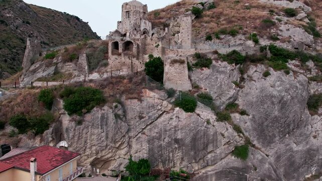 Drone on an ancient tower in Amantea, Italy. On a high hill on the seashore above the city. A cloudy summer day