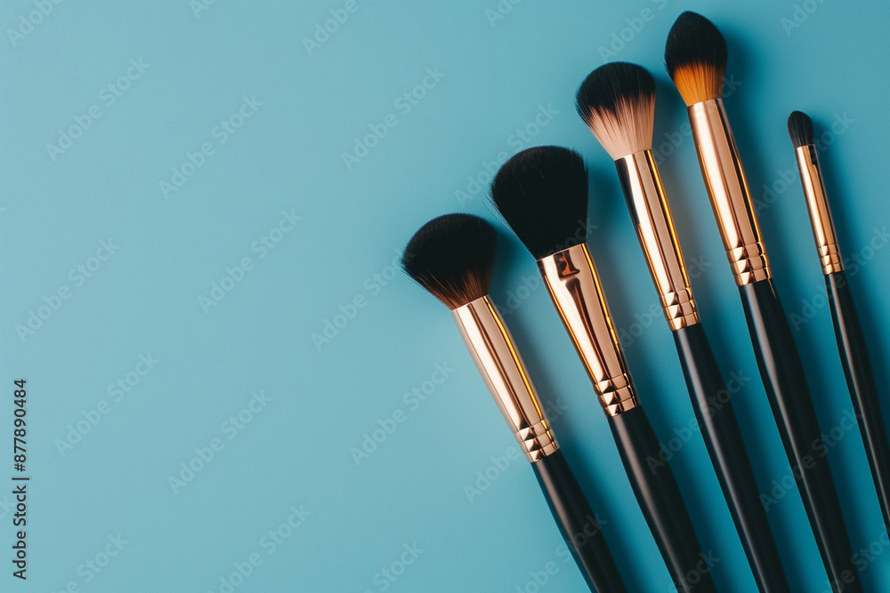 Poster row of makeup brushes are displayed on a blue background. the brushes are of different sizes and col