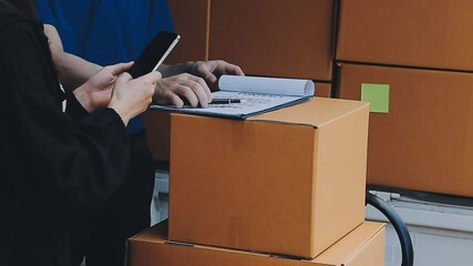 Young cheerful delivery man with parcel near car full of cardboard boxes, full length shot. Shipping service concept