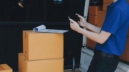 Young cheerful delivery man with parcel near car full of cardboard boxes, full length shot. Shipping service concept
