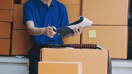 Young cheerful delivery man with parcel near car full of cardboard boxes, full length shot. Shipping service concept