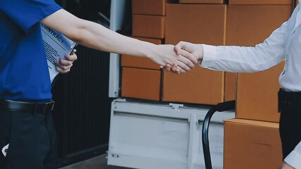 Young cheerful delivery man with parcel near car full of cardboard boxes, full length shot. Shipping service concept