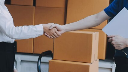 Young cheerful delivery man with parcel near car full of cardboard boxes, full length shot. Shipping service concept