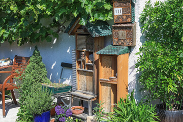 Beautiful cottage garden scene showing a homemade insect  or bee hotel for wild bees and insects withmade with different materials for different insets for nesting bees
