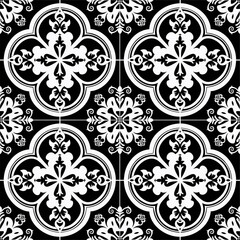 Fototapeta premium A seamless pattern of vintage black and white tiles with intricate geometric and floral designs, featuring circular motifs with cross-like symbols and symmetrical leaf-like elements.