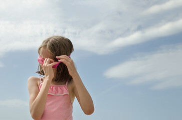 Child on the shore puts on goggles for swimming