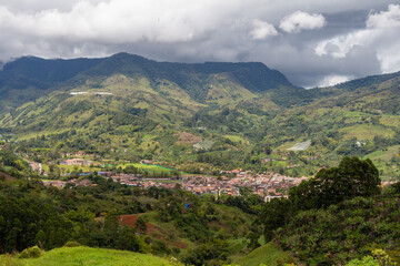 Cityscape of Jardin, Jardín, Antioquia, Colombia. Awesome landscape with the green Andes Mountains and a dramatic cloudy sky.