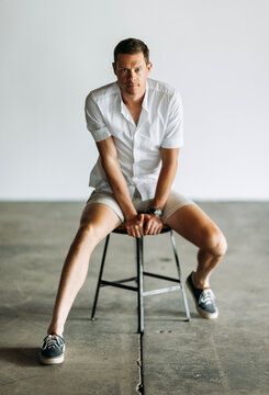 39 year old male in white shirt and shorts poses for portrait