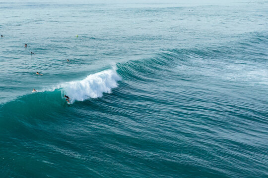 A drone view of a surfer about to get barreled in wave in Hawaii
